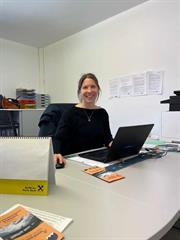Maria Kainzner sitzt am am Schreibtisch, arbeitet am Laptop